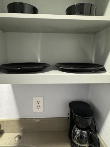two black toilets sitting on shelves in a kitchen at Hidden Treasure in Davenport