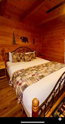 a bedroom with a bed with a bear on the wall at Prime Mountain Cabin - Near Galinburg Downtown in Gatlinburg