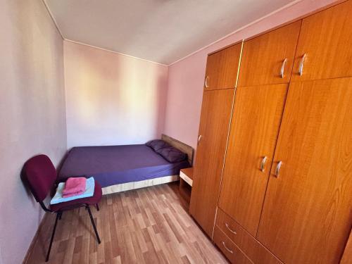 a small bedroom with a bed and a cabinet at Cozy Apartments zona Insula de agrement in Bacău