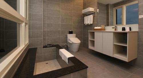 a bathroom with a toilet and a sink and a tub at 山水聽風會館 in Yuanshan