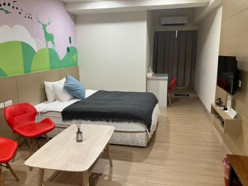um quarto com uma cama, uma mesa e cadeiras em Music City Inn em Kaohsiung