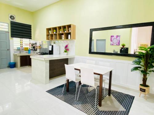 a dining room with a table and a mirror at D Palas Timur Homestay 10 Minit Ke Pusat Bandar KB in Wakaf Baharu