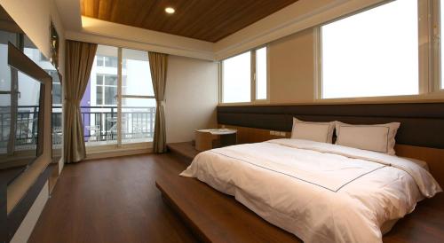 a bedroom with a large bed and large windows at 山水聽風會館 in Yuanshan