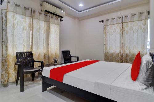 a bedroom with a bed and two chairs at Hotel O Shri Ganesh Near By Himayatnagar,Ashok Nagar,RTC X Roads in Hyderabad