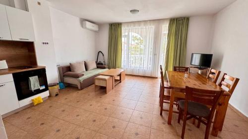 ein Wohnzimmer mit einem Tisch und einem Sofa sowie einem Tisch und Stühlen in der Unterkunft Fantastic Apartment in Sveti Vlas in Sweti Wlas