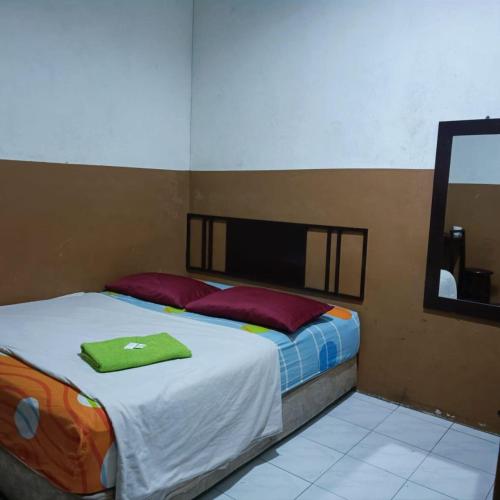 a bedroom with a bed with red pillows and a mirror at Meple Hotel Skudai in Skudai