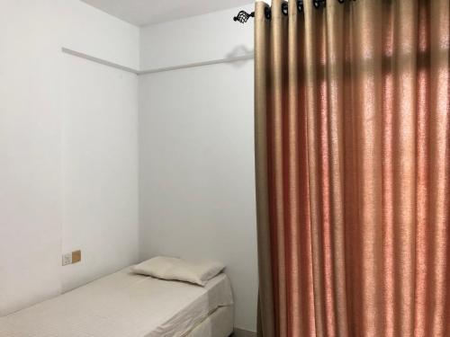 a bedroom with a bed and a shower curtain at Viyathpura in Nikawatawana