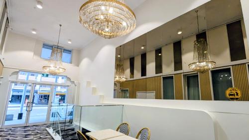 a lobby with chairs and chandeliers in a building at Ambassadors Hotel in Adelaide