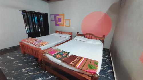 two twin beds in a room with a window at Gokarna Holiday Homes in Gokarna
