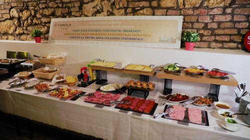 a table with many different types of food on it at Fibula Residence Hotel & Wellness - Adults Only in Pécs