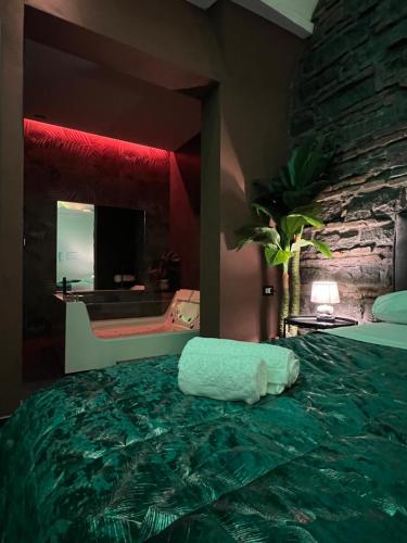 1 dormitorio con cama verde y pared de piedra en Il Casale del 900, en Catania