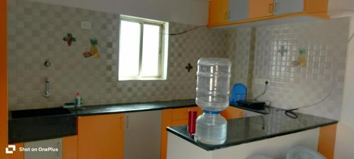 a kitchen with a counter with a plastic container on it at sahithya comfort homestay in Bengaluru