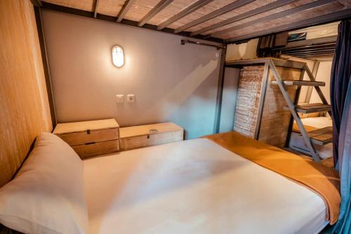 a small bedroom with a bunk bed and a ladder at Lushy Hostel Kintamani in Kubupenlokan