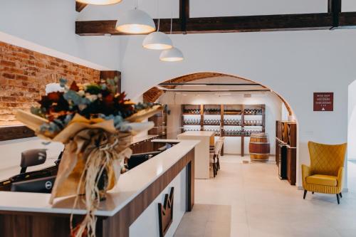 a restaurant with a counter with flowers on it at Wine & boutique hotel Terbotz in Štrigova