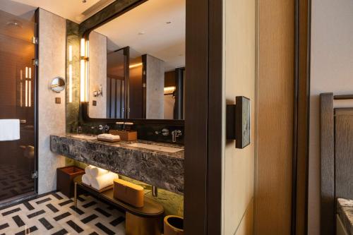 a bathroom with a sink and a mirror at Jianguo Hotel HUANQIU in Beijing