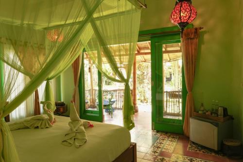 um quarto com uma cama de dossel em Bali Bohemia Huts em Ubud