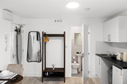 a bathroom with a shower and a toilet in it at Bright and Cozy Studio Flat for a Relaxing Stay in Greenford