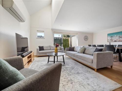 a living room with couches and a tv and a table at 63@CapeView, Geographe bay in Busselton