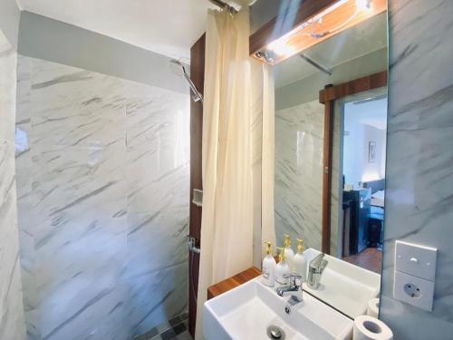 a bathroom with a white sink and a mirror at Andewi Cabin in Sempidi