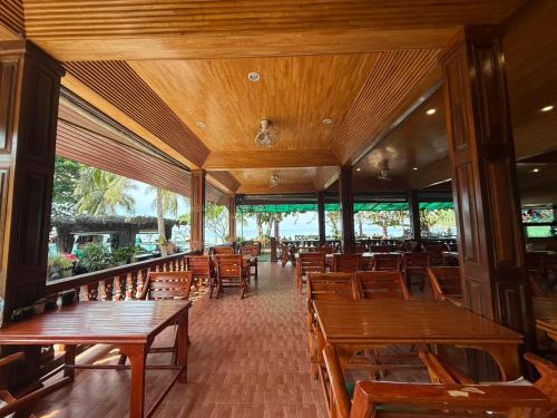 ein leeres Restaurant mit Holztischen und -stühlen in der Unterkunft Dreamland Resort in Thong Nai Pan Yai