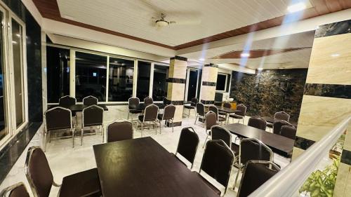 a conference room with tables and chairs and windows at Winter Cloud in Mahabaleshwar