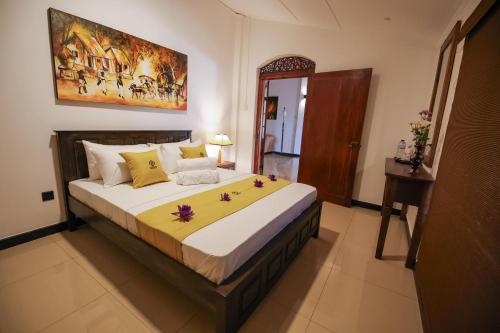 ein Schlafzimmer mit einem großen Bett mit Blumen darauf in der Unterkunft Heritage Kandy City Bungalow in Kandy