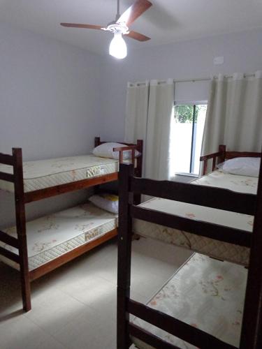 a room with three bunk beds and a ceiling fan at Casas para temporada em Bonito in Bonito