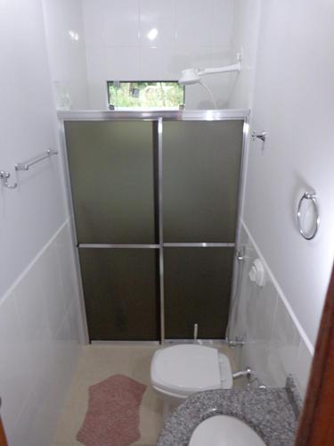 a small bathroom with a toilet and a window at Casas para temporada em Bonito in Bonito