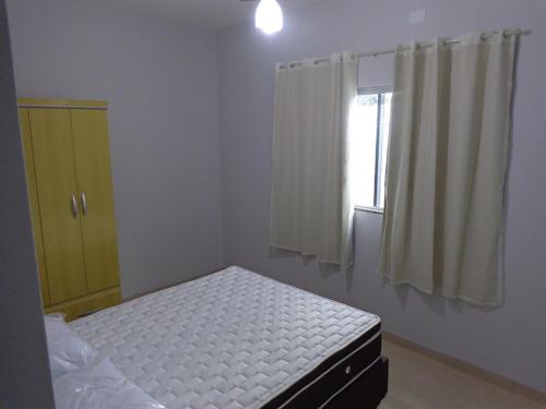 a small bedroom with a bed and a window at Casas para temporada em Bonito in Bonito