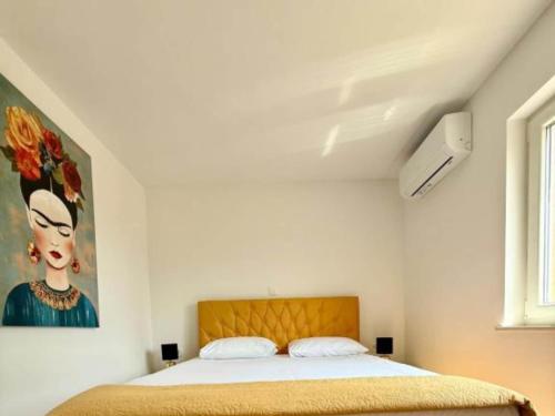 a bedroom with a bed with a painting on the wall at Four-Bedroom Apartment With Sea View in Sreser