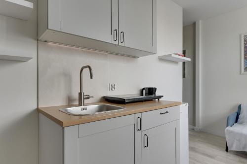 a kitchen with white cabinets and a sink at Gdynia Campus in Gdynia