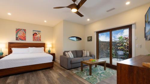 una camera da letto con un letto e un divano di ISLAND SEABATICAL Restful 3BR Ainamalu Home with Private Pool a Waikoloa