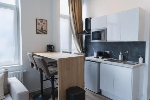 a small kitchen with a table and a microwave at Lovely 1BR & 1LR Apartment, Only 15 Min Walk to City Center in Ghent