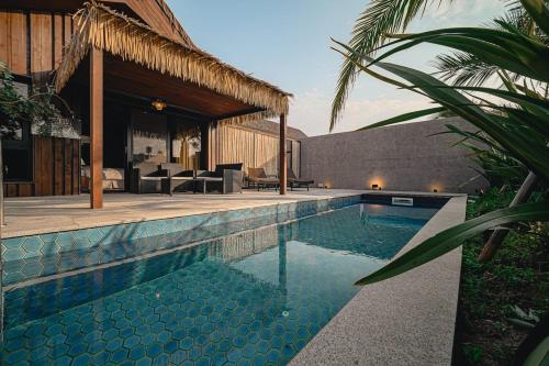ein Swimmingpool vor einem Haus in der Unterkunft Jeju Sentosa Hallim in Jeju-do