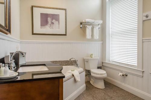 a white bathroom with a toilet and a sink at The Federal Pointe Inn Gettysburg, an Ascend Collection Hotel in Gettysburg