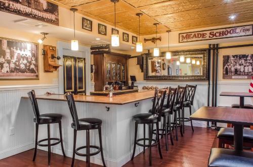 a bar with a bunch of stools in a restaurant at The Federal Pointe Inn Gettysburg, an Ascend Collection Hotel in Gettysburg