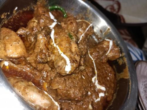 a metal bowl of food with meat and sauce at Kashmir Heights Hotel & Restaurant in Dargai