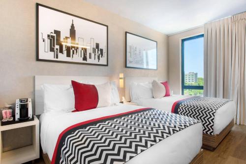a hotel room with two beds and a window at Insignia Hotel Brooklyn, an Ascend Collection Hotel in Brooklyn