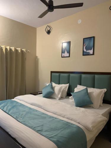 a bedroom with a large bed with blue and white pillows at Banyan Tree Resort in Ranakpur