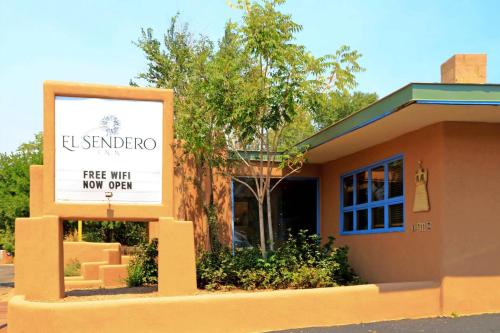 a sign in front of a building with a free wifi now open at El Sendero Inn, an Ascend Collection Hotel in Santa Fe