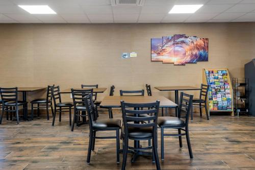 a dining room with tables and chairs and a painting on the wall at The Waves Hotel, an Ascend Collection Hotel in Wildwood