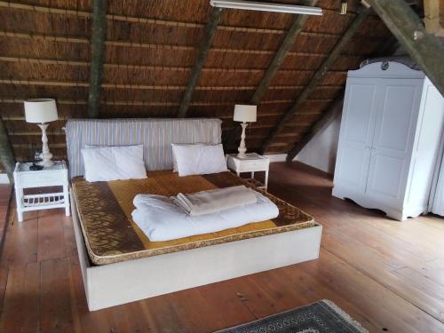 a bed in a room with two tables and two lamps at Rivers edge cottage in Stilbaai