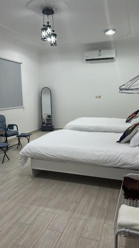 a bedroom with a large white bed and a chalkboard at alula3 in AlUla