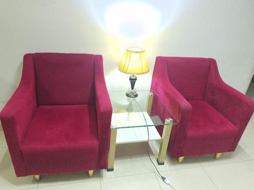 two chairs sitting next to a table with a lamp at Dream Palace Hotel in Dargai
