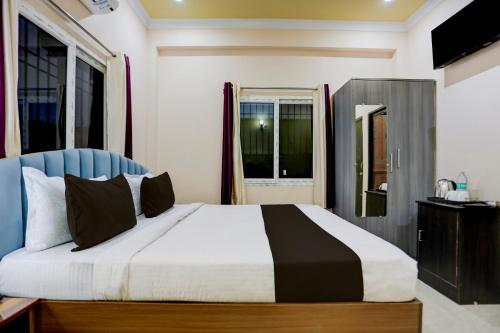 a bedroom with a large bed and two windows at Hotel O kumar inn in Lok Nayak Jayaprakash Airport