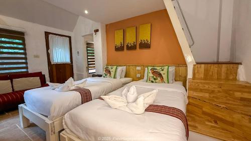 una camera con tre letti con lenzuola bianche di Pai Vintage Garden Resort a Pai