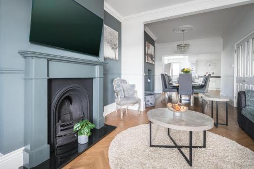 a living room with a fireplace and a table at Seafront folkestone Sandgate channel tunnel - 5 star property Sleeps 16 in Sandgate