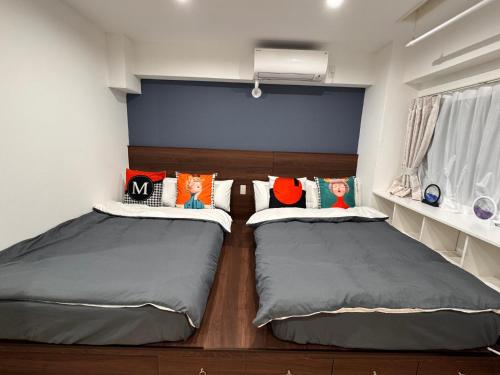 two beds in a small room with two at 四季安々2号店 in Kawaguchi
