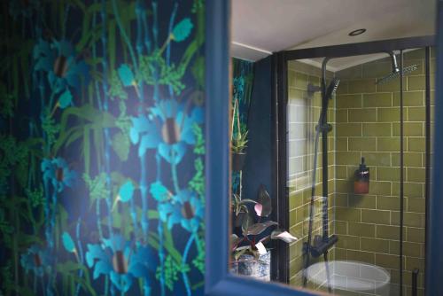 a bathroom with a shower with a mirror and a sink at The Floating Terrarium in London