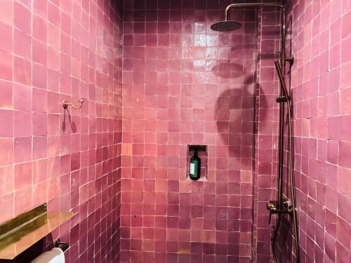 a pink tiled bathroom with a shower with a green light at Riad SASHA Exclusive&New Pool 6 pax Free Breakfast in Marrakech